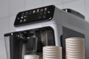 papier koffie cups en koffie machine in achtergrond foto