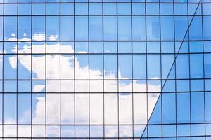 de reflectie van wolk in de ramen van modern kantoor gebouw foto