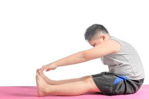 jongen aan het doen training naar verliezen gewicht Aan yoga mat geïsoleerd foto