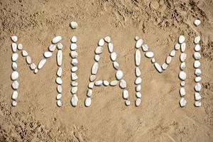 Miami - woord gemaakt met stenen Aan zand foto