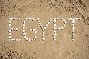 Egypte - woord gemaakt met stenen Aan zand foto