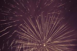 geel vuurwerk tegen paars nacht lucht achtergrond foto