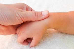 masseur aan het doen massage vingers weinig baby. foto