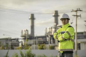 aziatische man petrochemisch ingenieur aan het werk bij de fabriek van de olie- en gasraffinaderij, de mensenarbeider man ingenieur werkcontrole bij de productie van de energiecentrale foto