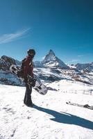 jong snowboarder uitgeven winter vakantie in Zermatt, in de buurt de beroemd matterhorn piek. mannetje poseren in Zwitsers Alpen voor de snowboarden seizoen. foto