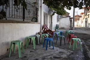 dorp leven, landelijk, dagelijks mensen routine, kleurrijk voetenbank, tabourets, gekleurde stoelen foto