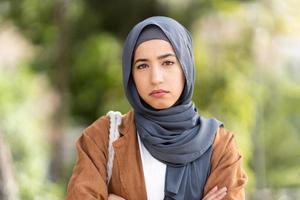 echt moslim vrouw in hijab kruispunt de armen ourdoors foto