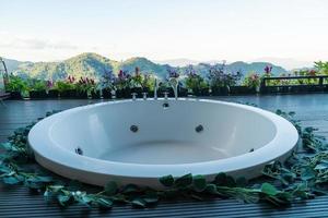 badkuip op balkon met bergheuvelachtergrond foto