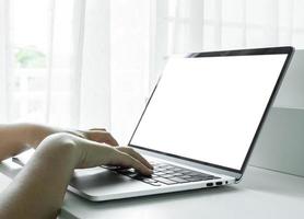 vrouw handen gebruik makend van laptop met blanco scherm Aan wit tafel Bij huis of kantoor. foto