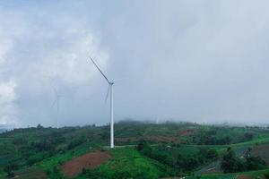 landschap van heuvels en wind turbines met nevelig mistig in ochtend- tijd. foto