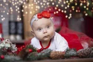 weinig baby Bij kerstmis. drie maanden oud meisje tegen de achtergrond van de Kerstmis boom decoratie. foto