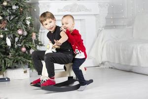 kinderen Speel in de Kerstmis kamer. twee broers ouderling en jonger in nieuw jaar decoraties. foto