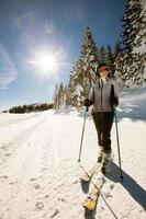 jong vrouw Bij winter skiën gelukzaligheid, een zonnig dag avontuur foto