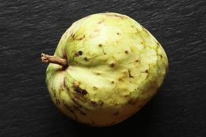 hele cherimoya fruit op leisteen achtergrond foto