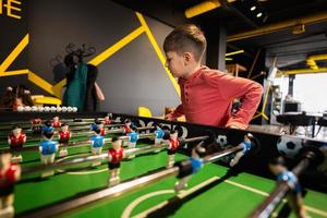 jongen spelen tafel Amerikaans voetbal in kinderen Speel centrum. foto