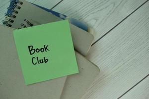 boekenclub geschreven op een notitieblok geïsoleerd op een houten tafel foto