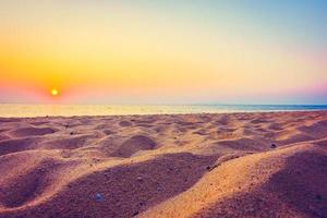prachtige zee en zand met zonsondergang foto
