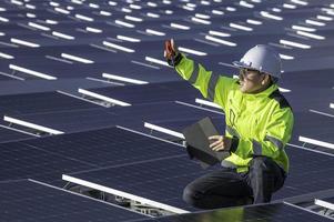 Aziatisch ingenieur werken Bij drijvend zonne- macht plant, hernieuwbaar energie, technicus en investeerder zonne- panelen controle de panelen Bij zonne- energie installatie foto