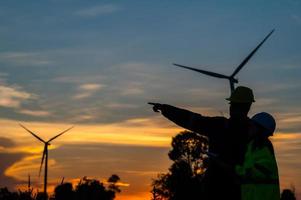 twee ingenieurs werken en Holding de verslag doen van Bij wind turbine boerderij macht generator station Aan berg, thailand mensen, technicus Mens en vrouw bespreken over werk ,gebruik dar visie van hoog hoek foto