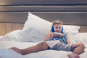 ontspannen jongen met smartphone op het bed foto