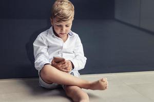 kleine jongen spelen op mobiele telefoon foto