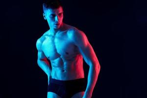 Mens met atletisch lichaamsbouw shows spieren gemotiveerd omhoog torso bodybuilder foto