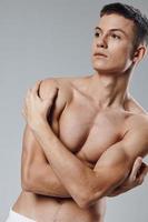 atleet met gemotiveerd spieren druk op bodybuilder grijs achtergrond bijgesneden visie foto
