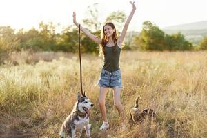 vrouw en haar schor hond gelukkig wandelen en rennen in de gras in de veld- glimlach met tanden herfst zonsondergang wandelen met een huisdier, op reis met een vriend hond geluk foto