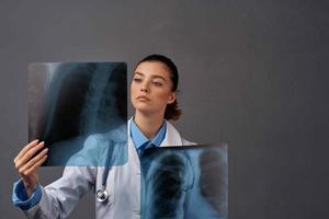 vrouw dokter wit jas röntgenstraal examen donker achtergrond foto