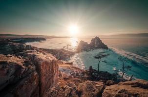 landschap van sjamanka rots Bij zonsondergang met natuurlijk breken ijs in bevroren water Aan meer Baikal, Siberië, Rusland. foto