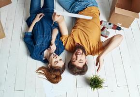 Mens en vrouw met dozen Aan de verdieping een bloem in een pot in beweging naar reparatie werk foto