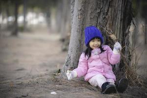 portret van schattig Aziatisch weinig meisje slijtage winter kleren Bij de Woud van de park, thailand mensen houding voor nemen een foto, gelukkig tijd foto
