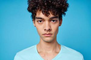 vent in blauw t-shirt gekruld haar- bijgesneden visie geïsoleerd achtergrond foto