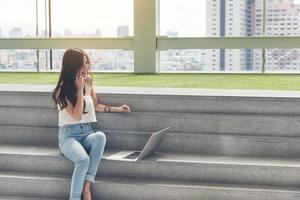 werkende vrouw met behulp van een telefoon en computer buiten foto