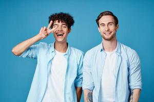 mannen in identiek overhemden en wit t-shirts Aan een blauw achtergrond chatten vrienden bijgesneden visie foto