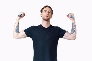 Mens met halters spieren spieren bodybuilder geschiktheid en tatoeëren Aan zijn arm foto