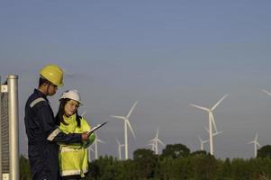 twee ingenieurs werken en Holding de verslag doen van Bij wind turbine boerderij macht generator station Aan berg, thailand mensen, technicus Mens en vrouw bespreken over werk ,gebruik dar visie van hoog hoek foto