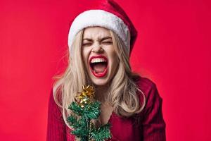 emotioneel vrouw in de kerstman kostuum mode Kerstmis boom met vakantie speelgoed foto