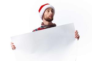 emotioneel Mens in een Kerstmis hoed met wit mockup poster Kerstmis geïsoleerd achtergrond foto