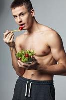 sportief Mens aan het eten salade aan het eten energie training levensstijl geïsoleerd achtergrond foto