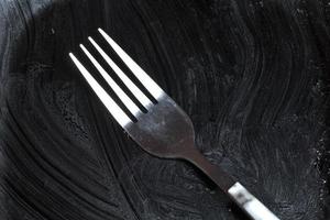 zwart vuil bord met vork foto