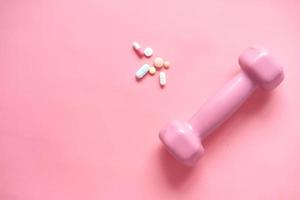 roze kleurenhalter en medische pillen op roze achtergrond foto