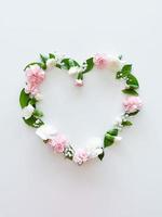 kader in het formulier van hart van roze, wit anjers foto