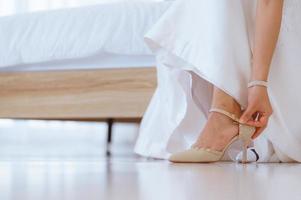 bruid hand- voorbereidingen treffen en aanpassen haar schoenen voordat bruiloft ceremonie foto