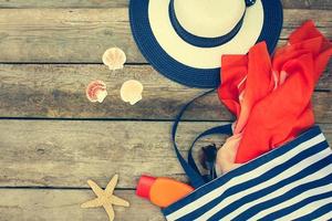 zomer vrouwen strand accessoires voor uw zee vakantie Aan oud houten achtergrond. afgezwakt afbeelding. foto