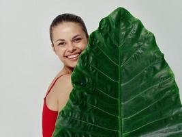 vrouw in rood zwempak palm blad exotisch charme foto