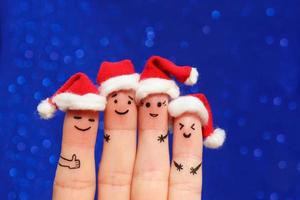 vinger kunst van vrienden viert kerstmis. de concept van een groep van mensen lachend in nieuw jaar hoeden. afgezwakt afbeelding. foto