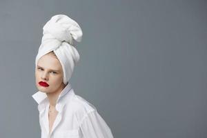 glamoureus vrouw wit overhemd schoonheidsmiddelen met handdoek Aan hoofd levensstijl poseren foto