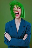 portret van een charmant dame vervelend een groen pruik blauw jasje poseren groen achtergrond ongewijzigd foto