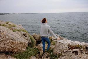 portret van een vrouw vrijheid wandelen Aan de steen kust vrouw ontspannende foto